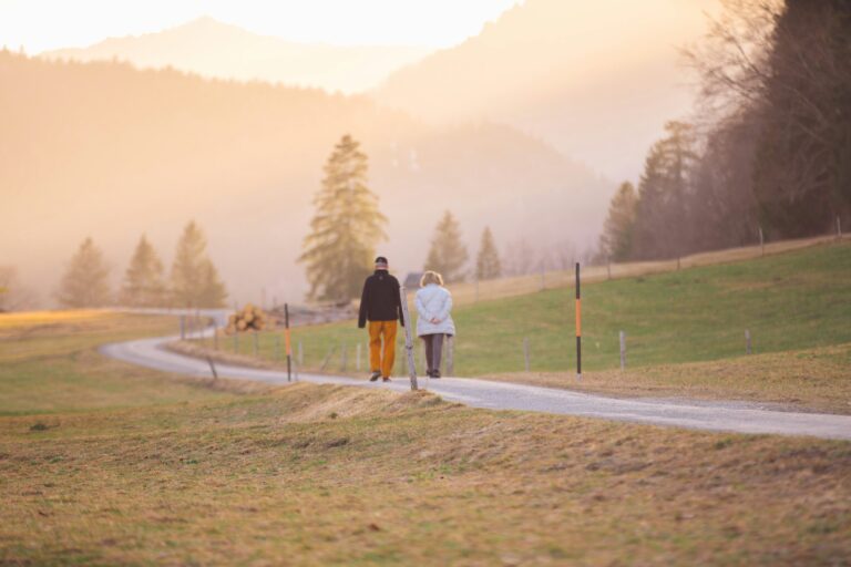 An older couple walking together through the countryside at sunset